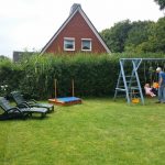 Garten vollständig durch Hecke umzäunt, mit Kletter- und Schaukelgerüst